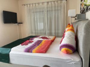 a bed with a colorful blanket on top of it at Pension Cao Lai in Varel