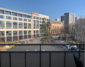 een uitzicht op een groot gebouw met een parkeerplaats bij Perfect location two bedrooms with balkony in Warschau