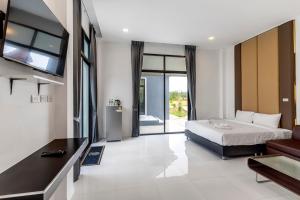 a hotel room with a bed and a tv at The Chill Villa Prachuap in Khao Khan Kradaj +33 photos