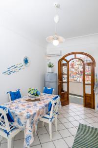 a dining room with a table and blue and white chairs at Mamma Mia in Positano