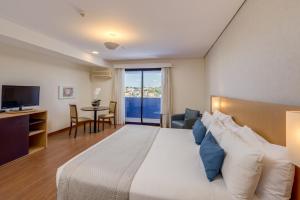Blue Tree Premium Londrina في لوندرينا: غرفه فندقيه سرير كبير وتلفزيون