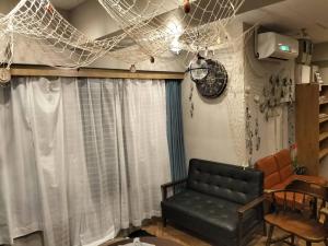 a living room with a couch and a net at bnb plus Ueno Park Female only in Tokyo