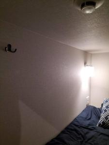 a bedroom with a bed and a light on the wall at bnb plus Ueno Park Female only in Tokyo