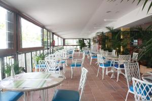 a row of tables and chairs in a room with windows at Paraiso del Sol y Paradero in Playa de las Americas