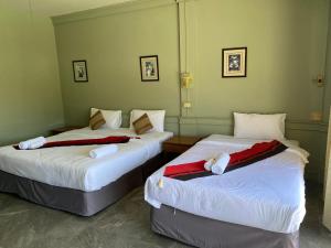 two beds in a hotel room with white sheets at Hotel Kata Hill Sea View in Kata Beach