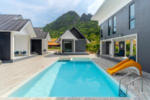 a pool with a slide in a house at The Chill Villa Prachuap in Khao Khan Kradaj