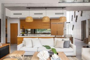 Una sala de estar con un sofá blanco y una cocina. en 33 Witta Circle, Noosa Heads, en Noosa Heads
