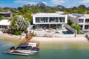 Una vista aérea de una casa con un barco en el agua. en 33 Witta Circle, Noosa Heads, en Noosa Heads