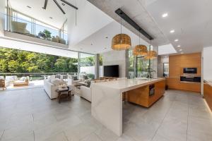 cocina abierta y sala de estar con ventanas grandes. en 33 Witta Circle, Noosa Heads, en Noosa Heads