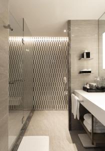 a bathroom with a shower, sink, and mirror at Centara Grand At Centralworld - SHA Extra Plus Certified in Bangkok