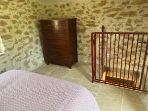 a bedroom with a crib and a dresser in a room at Cabanon entouré de montagnes et d'oliviers in Nyons