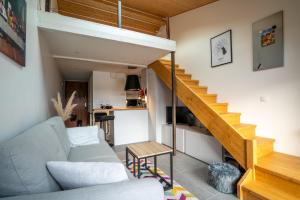 Una sala de estar con un sofá y una escalera. en CABANA & Sunset - Terrasse , Parking & Lac, en Veyrier-du-Lac