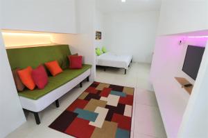 a living room with a green couch with colorful pillows at Cornerstone Bali Coworking in Canggu