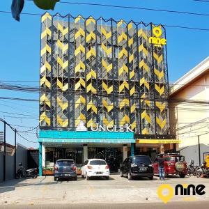 ein Gebäude mit gelben Schildern an der Seite in der Unterkunft Nine Hotel in Palembang