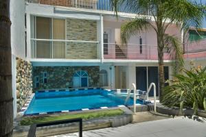 a villa with a swimming pool in front of a building at 3 VENATOR House Boutique in León
