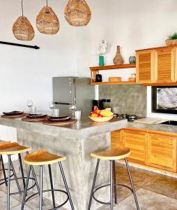 una cocina con una encimera grande con taburetes. en Bella & Palma Villas, en Haad Tian