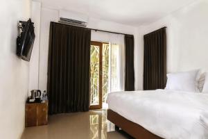 a bedroom with a large bed and a window at One South in Banyuwangi