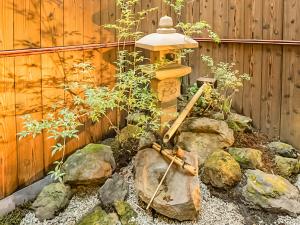 einen Garten mit einem Hydranten neben einem Zaun in der Unterkunft 慶有魚·八坂(Kyotofish·Yasaka)*近清水寺祗园5分钟*庭院地暖浴缸*京都民宿认证 in Kyoto