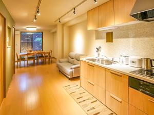 a kitchen and living room with a couch and a table at 慶有魚·八坂(Kyotofish·Yasaka)*近清水寺祗园5分钟*庭院地暖浴缸*京都民宿认证 in Kyoto