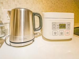 eine Kaffeekanne auf einer Theke neben einer Mikrowelle in der Unterkunft 慶有魚·八坂(Kyotofish·Yasaka)*近清水寺祗园5分钟*庭院地暖浴缸*京都民宿认证 in Kyoto