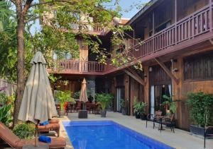 a resort with a swimming pool and a house at Three Little Birds in Siem Reap