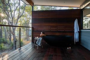 Un uomo è seduto in una vasca da bagno in bagno di Bina Maya Yallingup Escape a Dunsborough