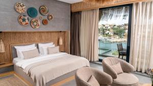 a bedroom with a bed and two chairs and a window at Sa'Rezya Hotel in Cesme