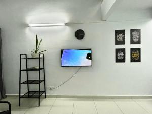 Elle comprend une télévision à écran plat suspendue sur un mur blanc. dans l'établissement Minimalist Loft IV @DeCentrum (Wifi/Netflix), à Kajang