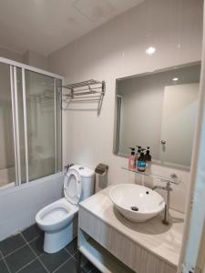 een badkamer met een wit toilet en een wastafel bij Peaceful 1-bedroom unit at Marina Island by JoMy Homestay in Lumut
