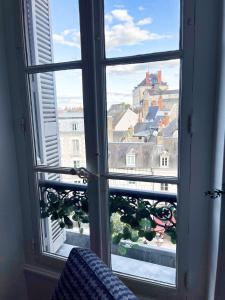 a window with a view of a city through it at ☆ Sur les toits de Blois ☆ T2 avec vue Château in Blois