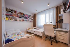 a bedroom with a bed and a desk and a chair at City Komfort Terrace in Košice