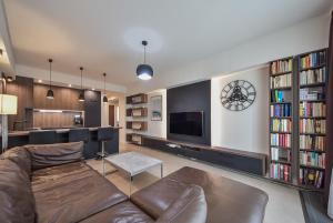 a living room with a couch and a tv and bookcases at City Komfort Terrace in Košice