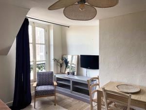 a living room with a desk and a tv at ☆ Sur les toits de Blois ☆ T2 avec vue Château in Blois