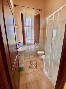 a bathroom with a toilet and a sink and a shower at Su Massaiu in Turri