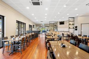 a dining room with wooden tables and chairs at The View On Hannans Kalgoorlie in Kalgoorlie