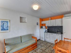 a living room with a couch and a table and a kitchen at Gîte le Chêne Vert in a holiday park with pool in Saint-Savinien