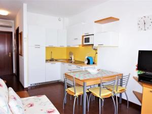 eine Küche mit einem Tisch und Stühlen im Zimmer in der Unterkunft Charming holiday home in Porto Santa Margherita with terrace in Porto Santa Margherita