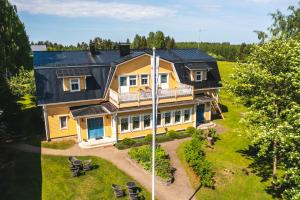 an aerial view of a yellow house with a balcony at B&B Lomamokkila in Savonlinna