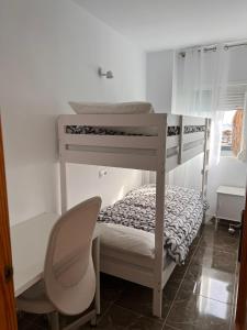 a bedroom with two bunk beds and a chair at Apartamento Carboneras playa - 2 Habitaciones in Carboneras
