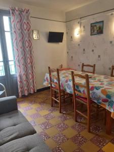 een kamer met een tafel en stoelen en een tafel en een bank bij Appartement 1er étage banyuls sur mer départs et arrivées les samedis in Banyuls-sur-Mer