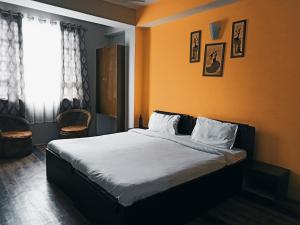 a bedroom with a bed with orange walls and a window at Mayal Retreat in Gangtok