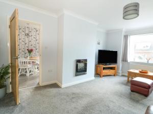 a living room with a television and a door at Snuffling Hedgehog in Lincoln