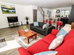 ein Wohnzimmer mit einem roten Sofa und einem Tisch in der Unterkunft 9 Breakwater Way in Sandown