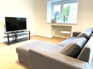 a living room with a couch and a flat screen tv at Sofia Apartments in Baden-Baden
