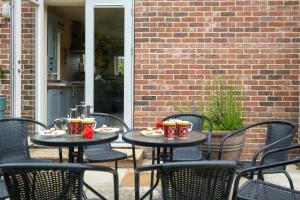 2 tafels en stoelen met drankjes op een patio bij Willow House in Aldringham