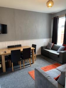 a living room with a table and a couch at Freya House in Gainsborough