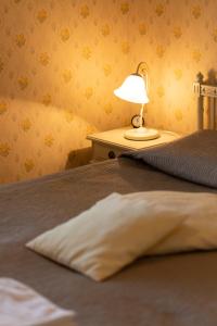 Cama con almohada y lámpara en una mesa en B&B Lomamokkila, en Savonlinna