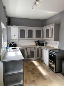 a kitchen with stainless steel appliances and white cabinets at Freya House in Gainsborough