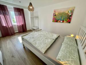 a bedroom with a bed and a painting on the wall at Sofia Apartments in Baden-Baden