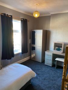 a bedroom with a bed and a desk and a window at Freya House in Gainsborough